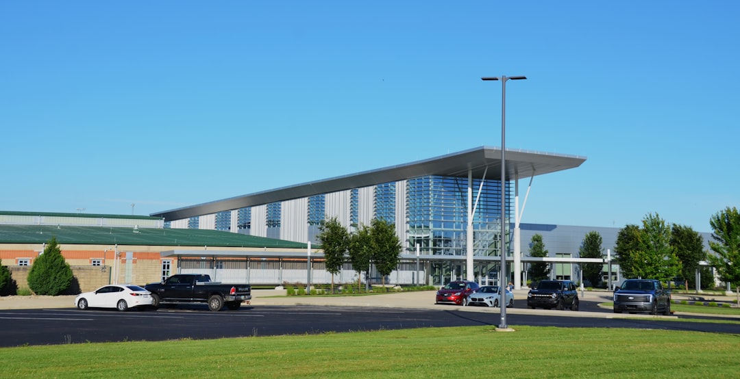 Contemporary building with a parking lot and clear blue sky.